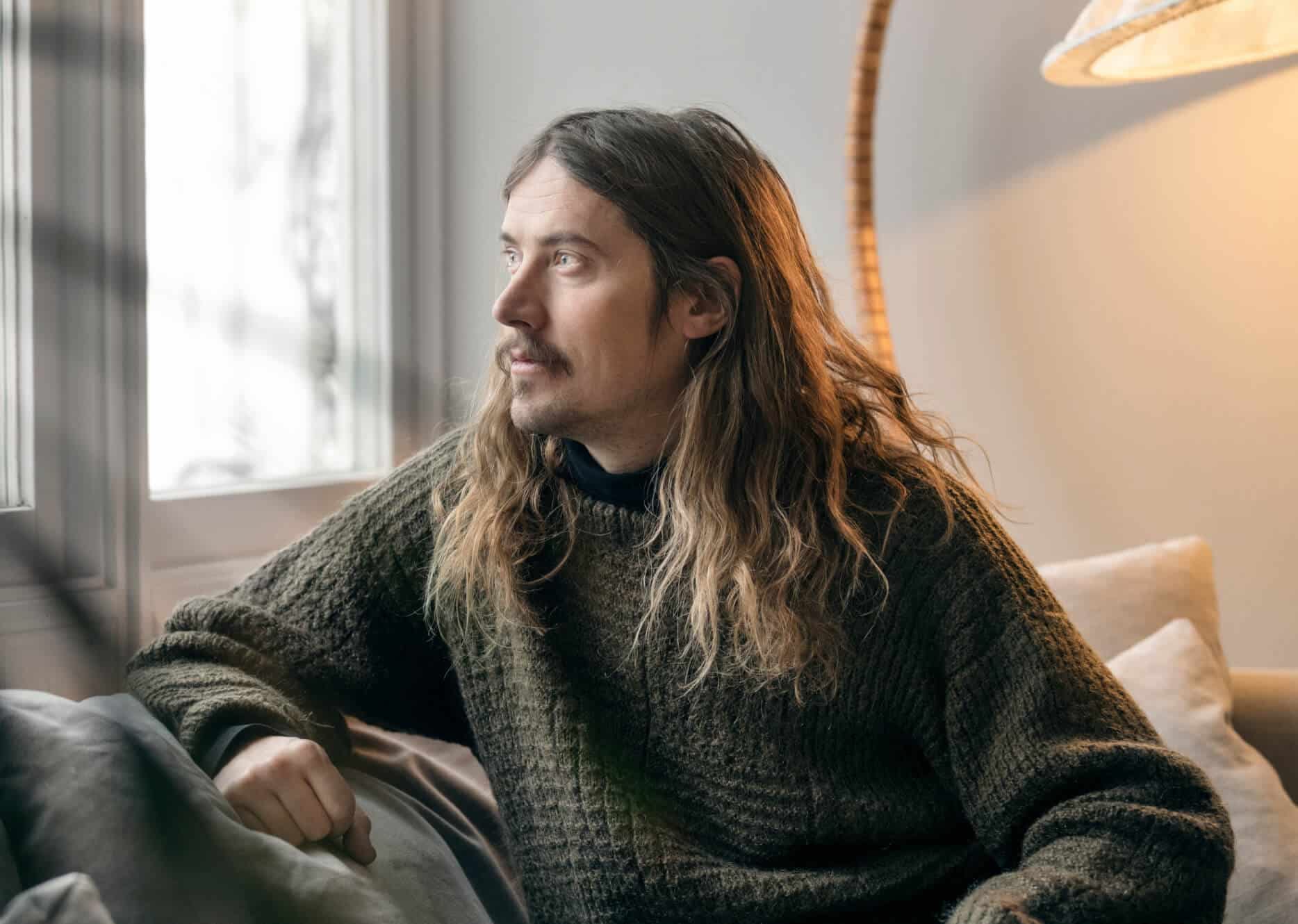 Thoughtful man at home reflecting on his mental health, a central focus of the health examination